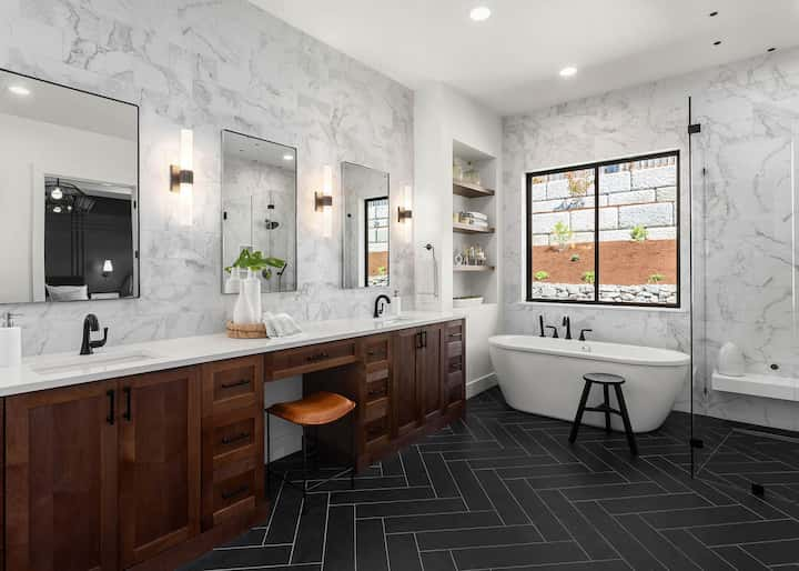 Complete bathroom remodel in West Palm Beach features a herringbone pattern floor and soaking tub.